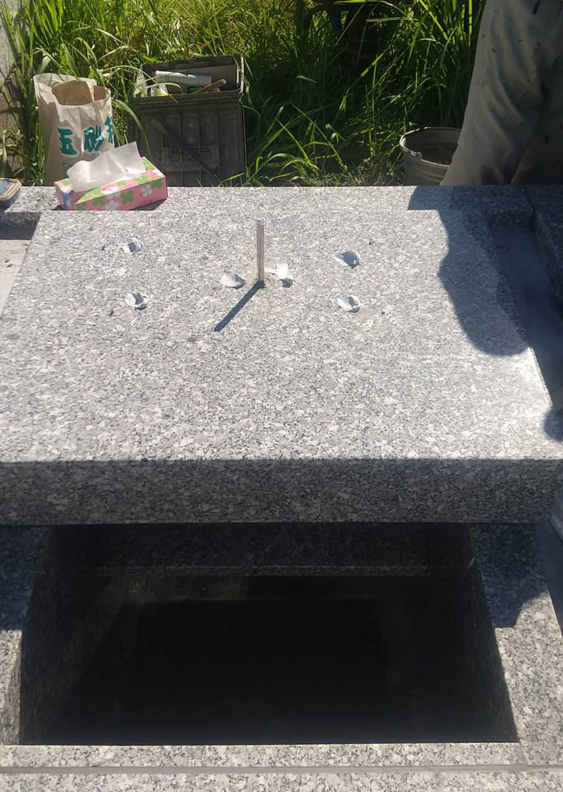 芝台に耐震用の心棒を通し、墓石部分を組み付けていきます。
