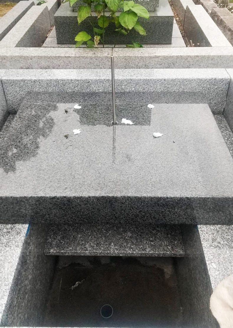 芝台（墓石の一番下になる部分）に耐震用の心棒を通し、墓石部分を組み付けていきます。